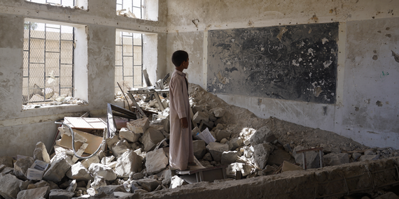 A young boy in Syria in the ruins of a classroom