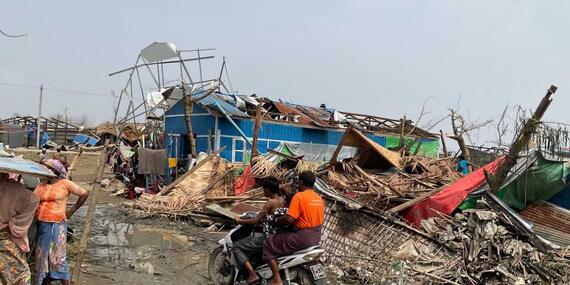 Men ride through the wreckage left by Cyclone Mocha