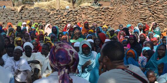 Aid workers listen to Internally displaced people in Darfur. 
