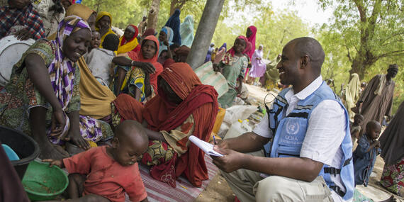 Am OCHA staff member speaks with a mother and her child