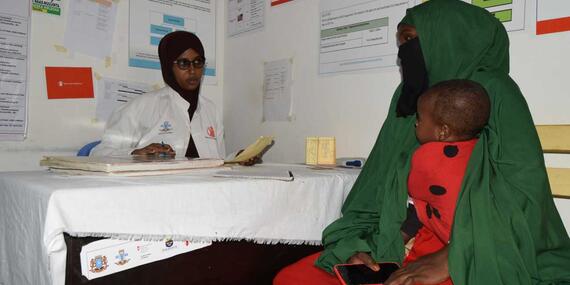 Sadia attends to a mother who brought her child to the nutrition centre.