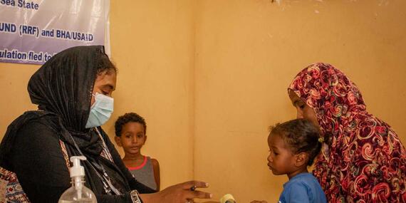 A mother and her children consult a medical practitioner