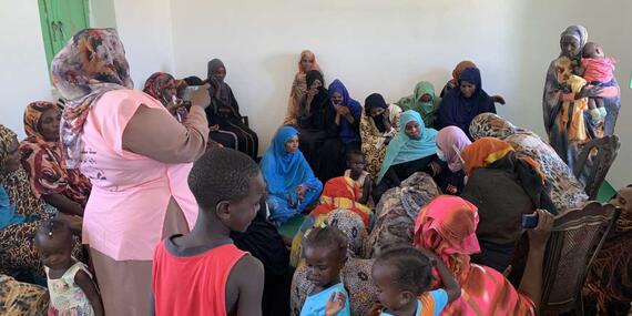 Aid workers hold a discussion with community members in a village in Sudan.