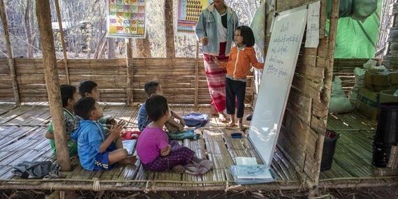 A volunteer teacher gives a lesson to children a camp for the displaced in Kayah State, eastern Myanmar. 
