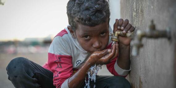 Nine-year-old Mahmoud takes a sip at the water distribution point in Al Rebat camp for internally displaced people in Lahj, Yemen. 