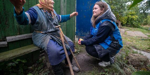 An elderly Ukrainian woman talks to an OCHA staff member