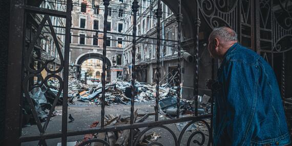 Elderly man looks upon the devastation of war in Ukraine