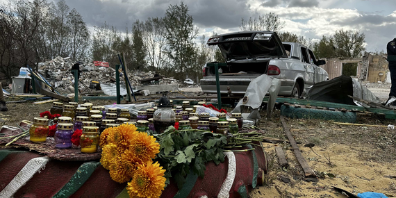 Flowers and candles placed near a wreckage