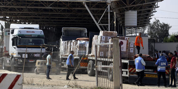 Men in UN vests load boxes on trucks