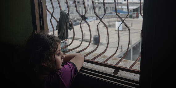 A Palestinian girl looks out of her window amid the ongoing hostilities in the Gaza Strip.