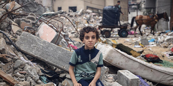Eight-year-old Mohammed Alattar sits among the rubble of his family’s house in Rafah City, which was bombed during an Israeli air strike.