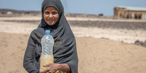 A woman carries contaminated water in a bottle due to frequent droughts in Ethiopia's Afar region