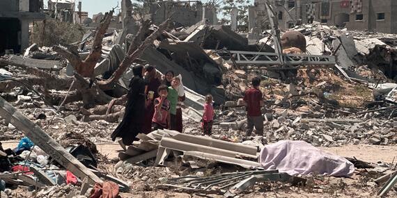 People amid a destroyed area in Khan Younis