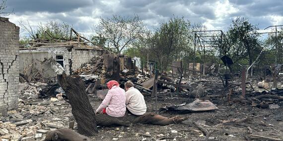A woman and a man sit amid ruins in Dnipro, Ukraine.