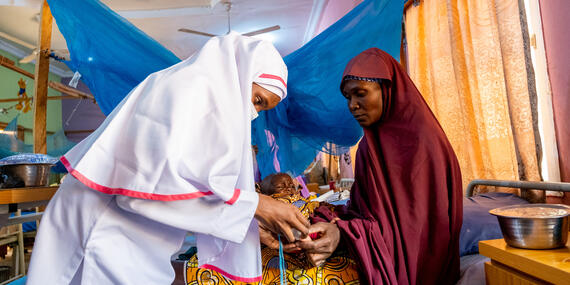 A healthcare worker attends to a malnourished child in Nigeria, highlighting the ongoing humanitarian efforts to combat malnutrition and support vulnerable communities
