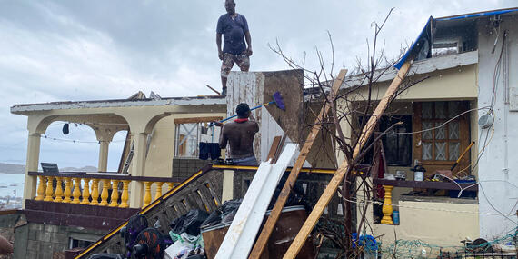Men in Grenada try to fix a roof in the aftermath of Hurricane Beryl. The hurricane caused severe damage to infrastructure, services and livelihoods in Grenada, Saint Vincent and the Grenadines, and Jamaica.