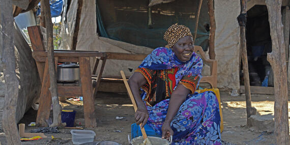 A woman seats in an open space preparing a meal in Bor internal displacement camp site in Jonglei State, South Sudan