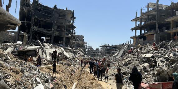 Residents walk through the rubble and destruction in Gaza, surveying the aftermath of recent conflict.