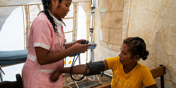 A nurse takes the blood pressure of a woman at a mobile clinic in a village in Madagascar’s Amboasary region. Photo: OCHA/ Viviane Rakotoarivony .