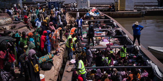 Aid workers assist returnees from Sudan at the port in Renk, South Sudan