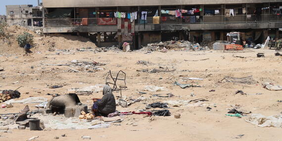 A woman cooks outside in Gaza