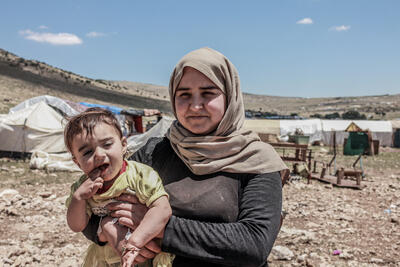 Mother and child in front of a camp for those internally displaced