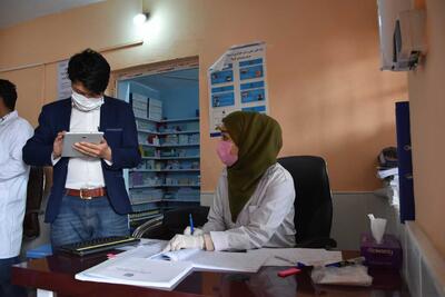 A woman wearing a face mask working in an office