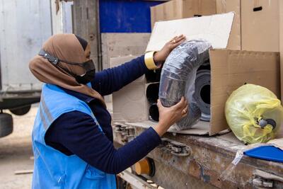 A woman checks aid supplies in the back of a lorry