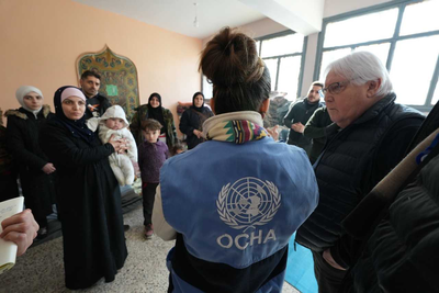 Mr. Griffiths talks with affected families at a shelter run by local NGO Al Ihsan in a school. 