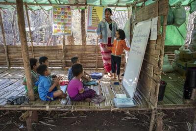 A volunteer teacher gives a lesson to children a camp for the displaced in Kayah State, eastern Myanmar. 