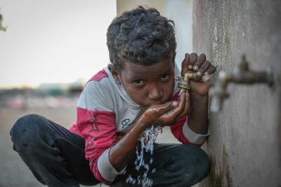 Nine-year-old Mahmoud takes a sip at the water distribution point in Al Rebat camp for internally displaced people in Lahj, Yemen. 