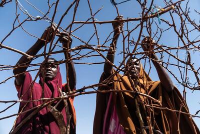 Sisters Hawa and Asha build a shelter at a camp for internally displaced people in Doolow, Somalia. 