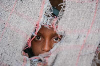 An 11 years old internally displaced girl looking out of her tent at Al Rebat IDPs Camp in Lahj, Yemen. 