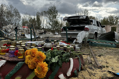 Flowers and candles placed near a wreckage