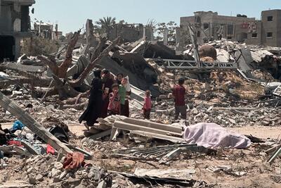 People amid a destroyed area in Khan Younis