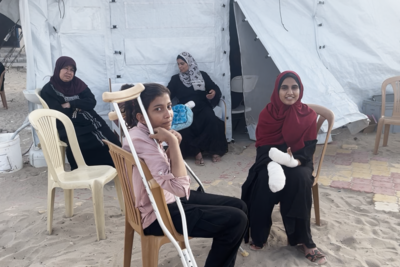 Girls sitting at a field hospital run by International Medical Corps after receiving medical treatment for injuries sustained in a 26 May strike on a site for displaced people in Rafah.