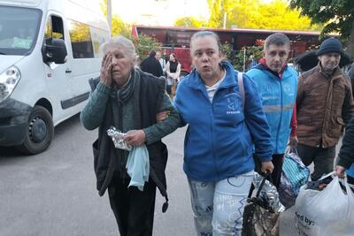 Aid workers assist an older woman to evacuate from the Kharkiv Region, east of Ukraine, amid intensified attacks.