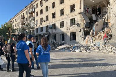 Humanitarians assess the damage to an apartment building in Ukraine's Kharkiv city following a recent attack.