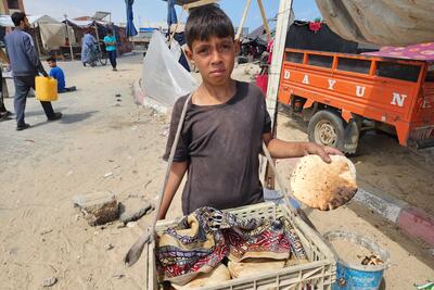 Youssef, 13, carries bread for his family in Al Mawasi. Gaza