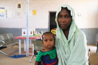 A woman holds a baby on her lap inside a treatment centre in Rann, Borno State, Nigeria