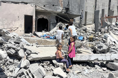 Children play by a damaged building following the latest round of fighting between Israel and Palestinian militants