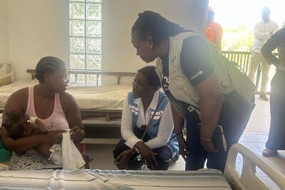 OCHA's Director of Operations and Advocacy, Edem Worsornu, listens to a patient at a hospital in Gonaives, Haiti. Photo: OCHA/Alexandra Bonvalot