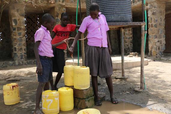Children fetch water from a church for their school. 