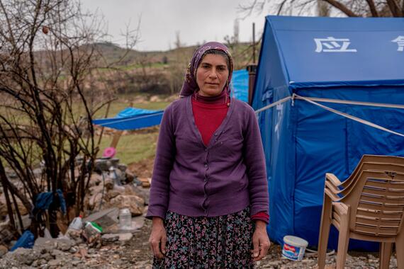A woman standing in front of a makeshift home