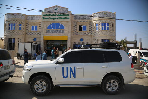 A Un marked vehicle stands outside a building.