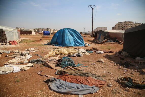 Scattered remains of clothes and other debris on the ground amid camps