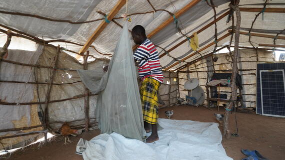 Jaffar arranges his bedding inside a tent at the Centre Village displacement site