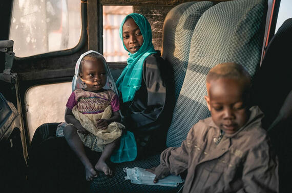 A mother and her children sit inside a vehicle after fleeing the war in Sudan.