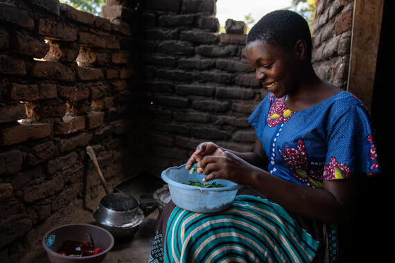 Mika, 20, adds moringa leaves to the nutritious porridge she’s preparing for her 4-year-old son, Raymon.