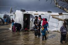 Syrian refugees walk through the flooded streets of Dalhamiya informal settlement in Bekaa Valley, Lebanon, January 2019.